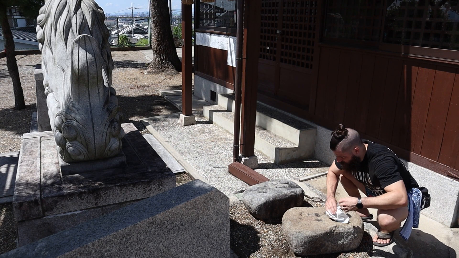 David 'Tamotsu' Dunlap cleans dirt from a stone.