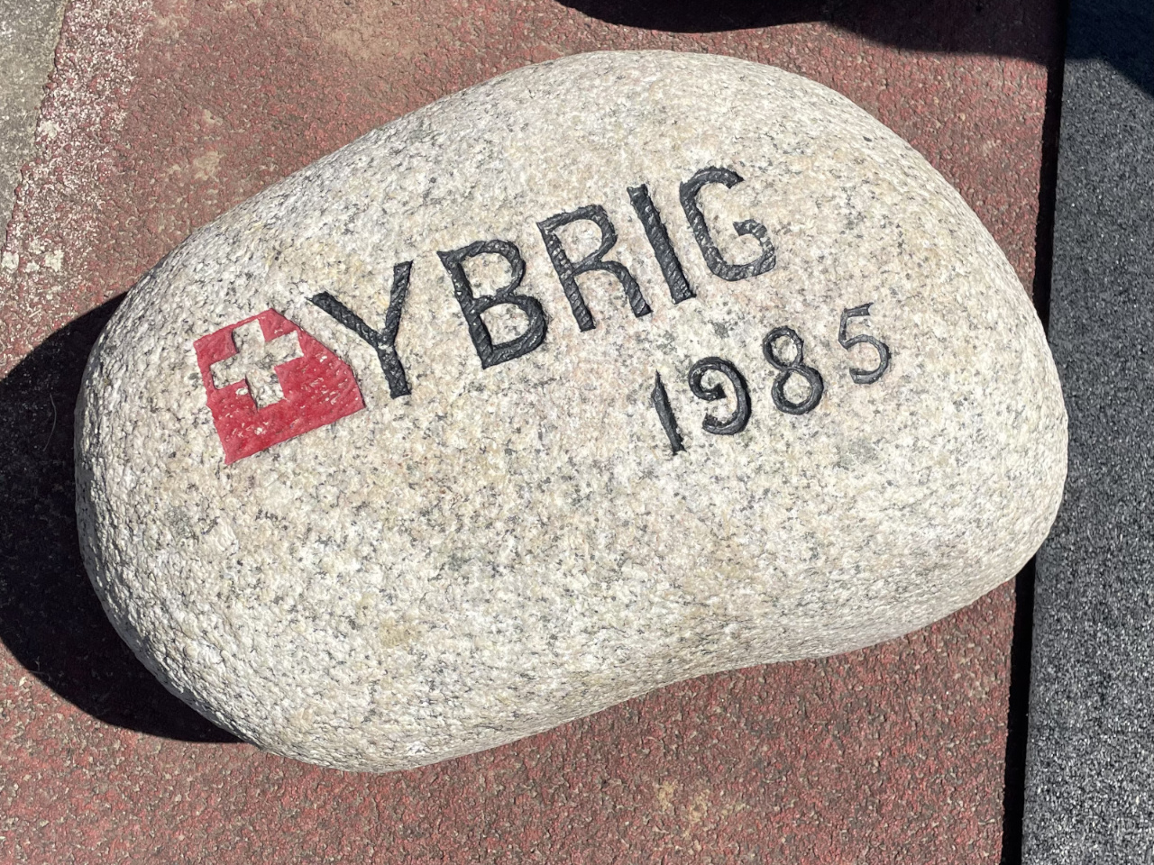 The Ybrig Stone lying on the ground with its engravings face up. The slightly odd shape is much more noticeable on the right-hand side, where it bulges out.